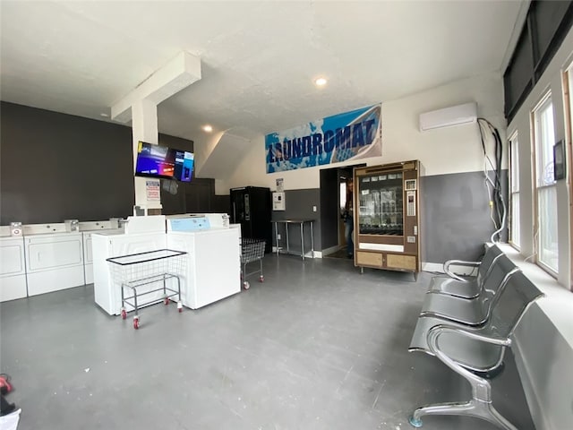 living room with washing machine and dryer, plenty of natural light, and a wall mounted air conditioner