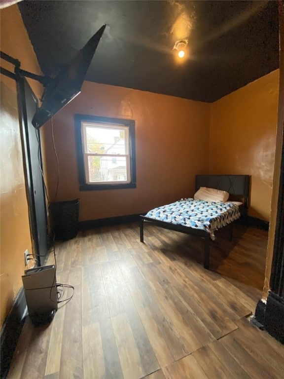 bedroom with hardwood / wood-style floors and vaulted ceiling