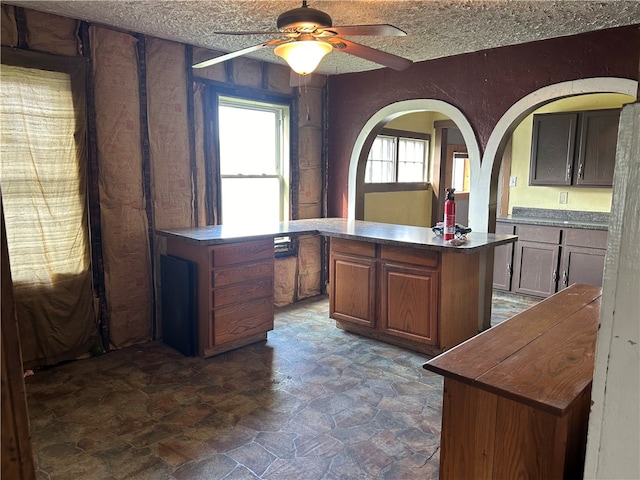 unfurnished office featuring a textured ceiling and ceiling fan