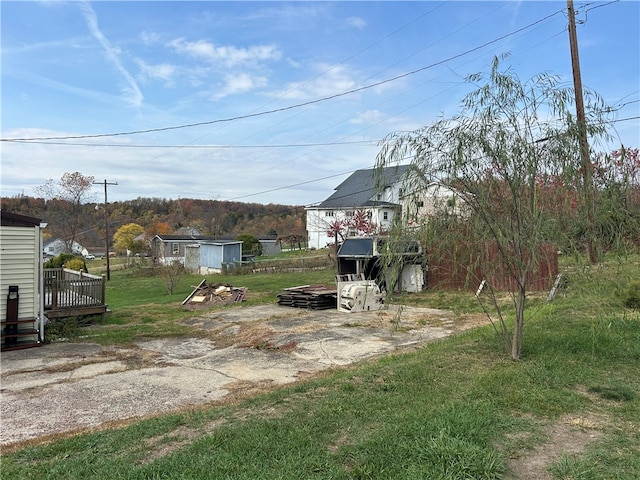 view of yard featuring a storage unit and a deck