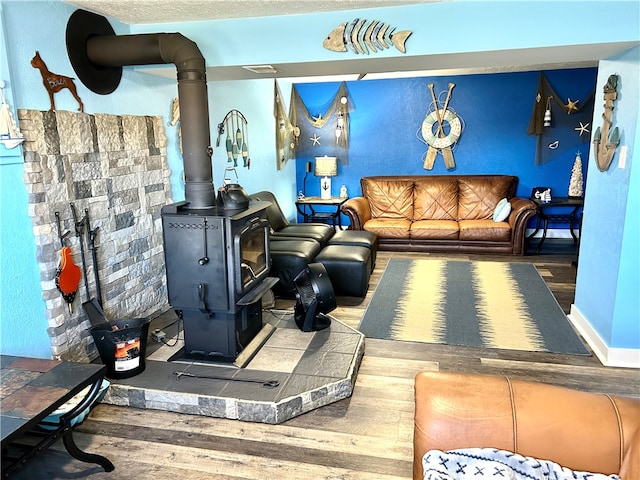 living room featuring a wood stove and wood-type flooring