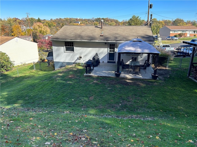 back of property featuring a lawn, a patio, and a gazebo