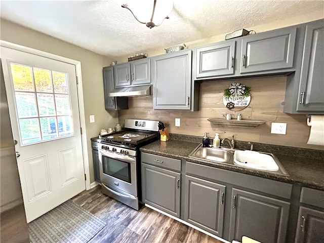 kitchen featuring gray cabinets, backsplash, stainless steel gas stove, and dark hardwood / wood-style floors