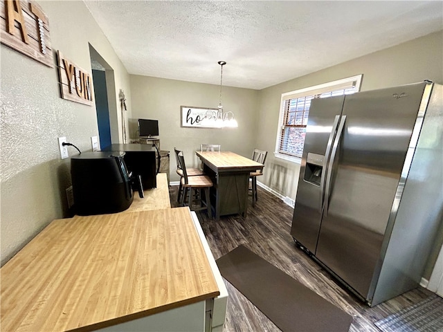 kitchen featuring butcher block counters, an inviting chandelier, a kitchen island, stainless steel fridge with ice dispenser, and dark hardwood / wood-style flooring