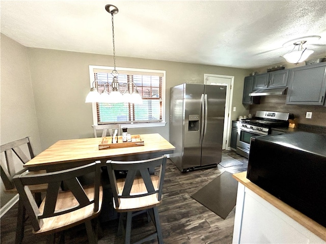 kitchen with stainless steel appliances, a notable chandelier, gray cabinets, dark hardwood / wood-style floors, and pendant lighting