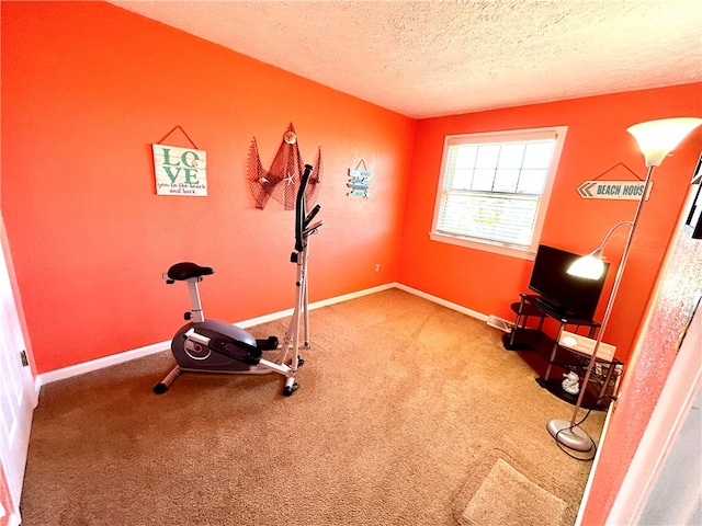 exercise room with carpet and a textured ceiling