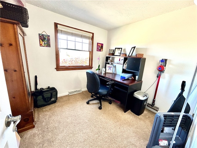 carpeted home office featuring a textured ceiling