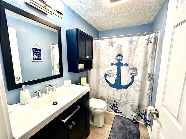 bathroom featuring toilet, hardwood / wood-style floors, a textured ceiling, a shower with curtain, and vanity