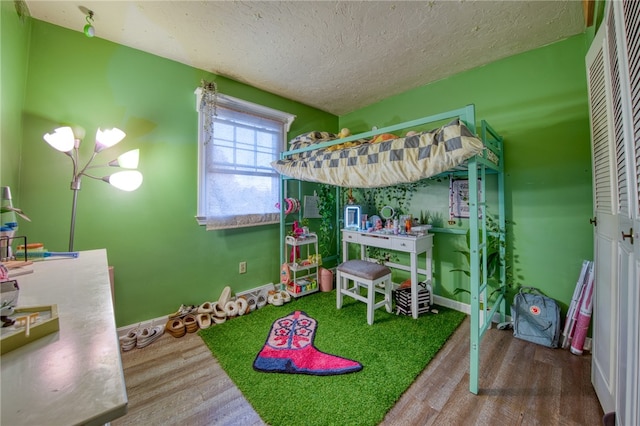 bedroom featuring hardwood / wood-style floors and a textured ceiling