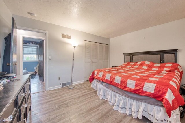 2759 Brodhead Rd, Aliquippa, PA 15001 - bedroom with light wood-style floors, a textured ceiling, and a closet