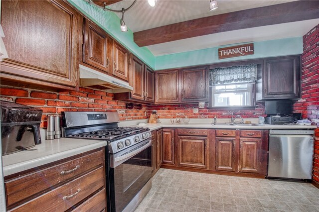 kitchen featuring appliances with stainless steel finishes, brick wall, sink, and beam ceiling