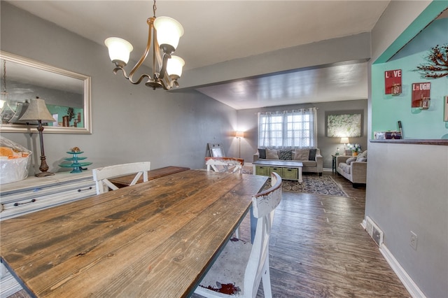 dining room featuring dark wood-type flooring and a chandelier