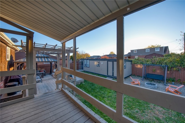 wooden deck featuring a pergola and a storage shed