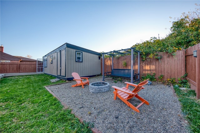 view of yard featuring a fire pit and a storage unit