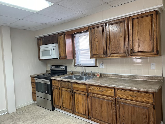 kitchen featuring stainless steel electric range, a paneled ceiling, sink, and tasteful backsplash