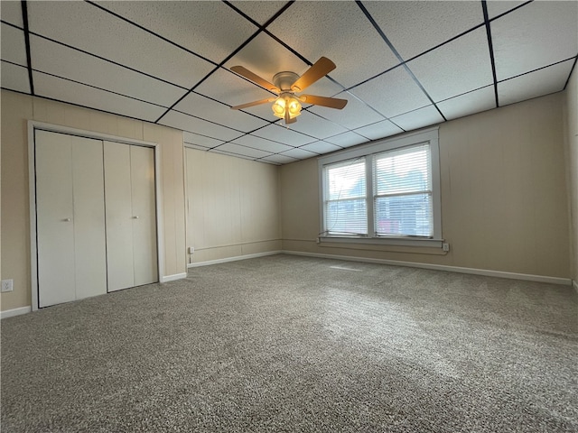 unfurnished bedroom with carpet flooring, a paneled ceiling, and ceiling fan