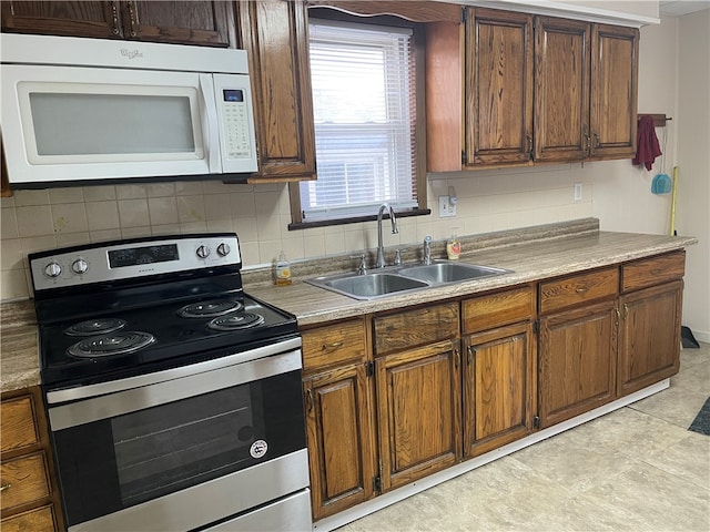 kitchen with tasteful backsplash, stainless steel electric range, and sink