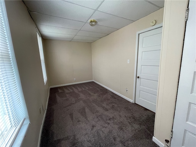 carpeted spare room featuring a paneled ceiling