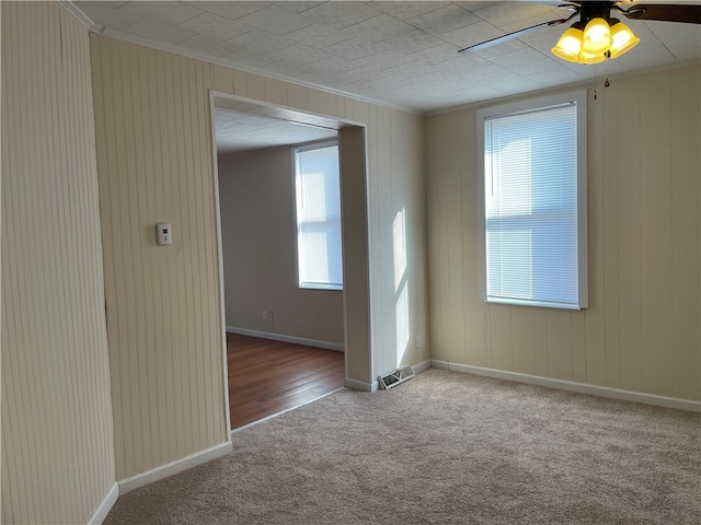 carpeted empty room featuring ceiling fan and ornamental molding