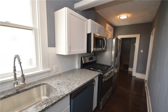 kitchen with stainless steel appliances, white cabinetry, decorative backsplash, sink, and dark wood-type flooring