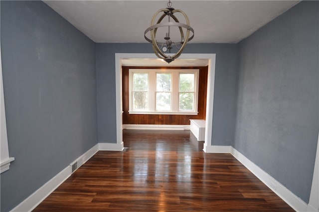 unfurnished dining area with baseboard heating, dark hardwood / wood-style flooring, and a chandelier