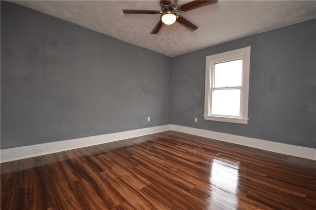 spare room with dark wood-type flooring and ceiling fan