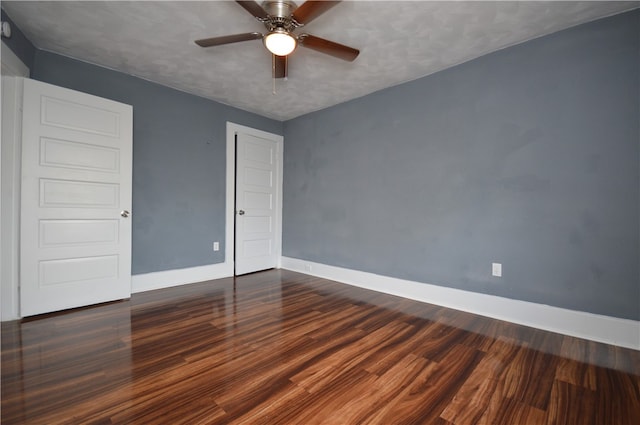 empty room featuring a textured ceiling, dark hardwood / wood-style floors, and ceiling fan