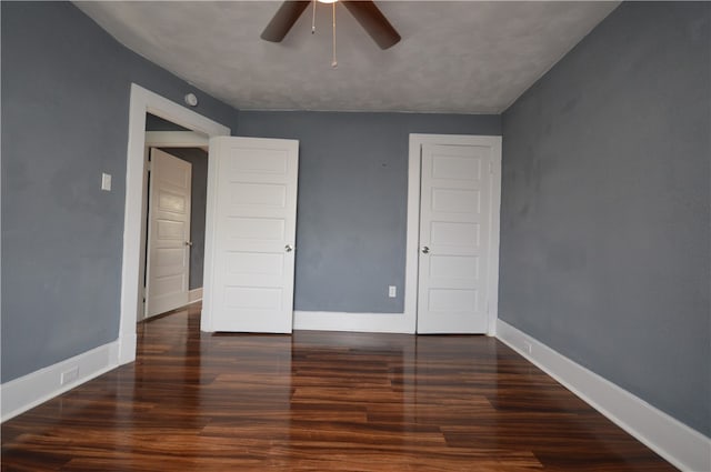 unfurnished bedroom featuring dark hardwood / wood-style flooring and ceiling fan