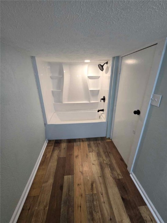 bathroom with shower / bath combination, hardwood / wood-style floors, and a textured ceiling