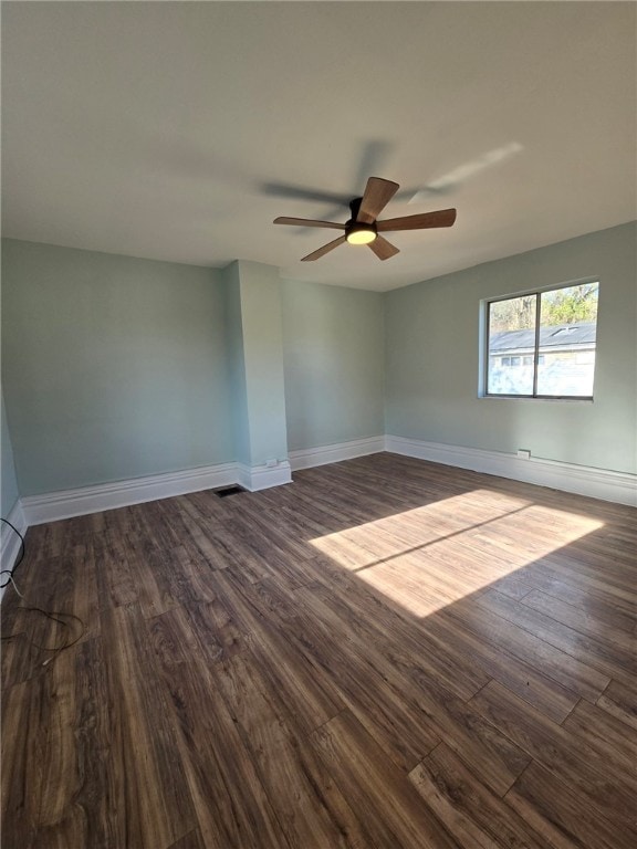 unfurnished room with dark hardwood / wood-style flooring and ceiling fan