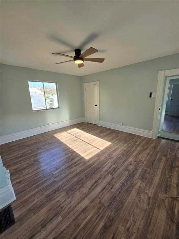 empty room with dark wood-type flooring and ceiling fan