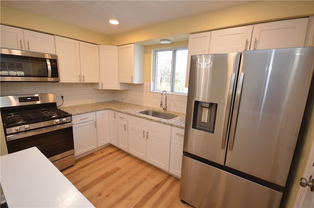 kitchen featuring white cabinetry, sink, decorative backsplash, and appliances with stainless steel finishes