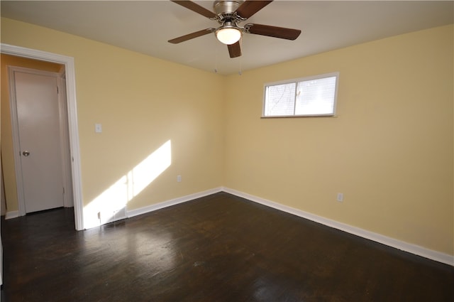 spare room featuring dark wood-type flooring and ceiling fan