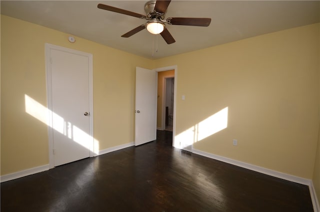 empty room featuring dark wood-type flooring and ceiling fan