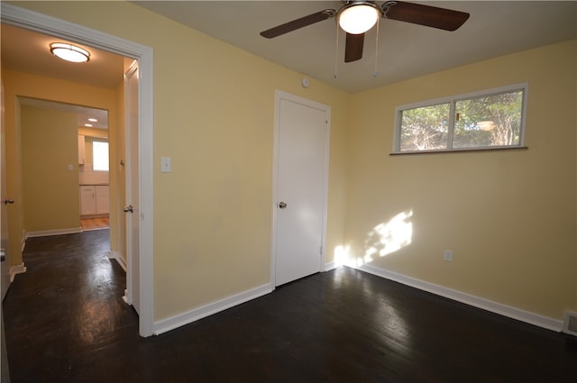 unfurnished bedroom featuring dark hardwood / wood-style flooring, multiple windows, and ceiling fan