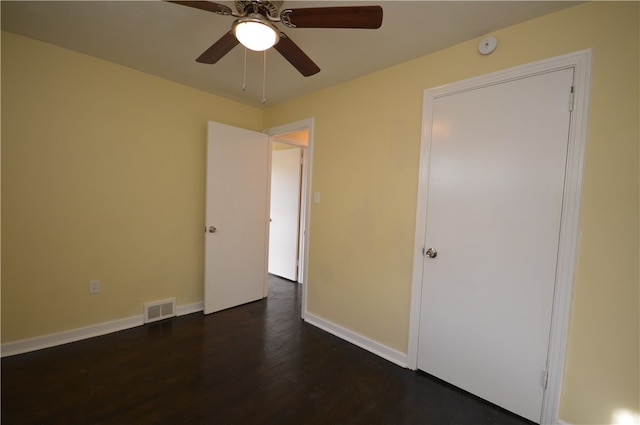 unfurnished bedroom featuring ceiling fan and dark hardwood / wood-style floors