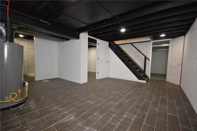 basement featuring dark wood-type flooring and gas water heater