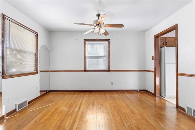 unfurnished room featuring light wood-type flooring, a wealth of natural light, and ceiling fan