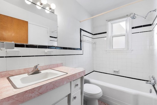 full bathroom with tasteful backsplash, tile walls, vanity, tiled shower / bath combo, and toilet