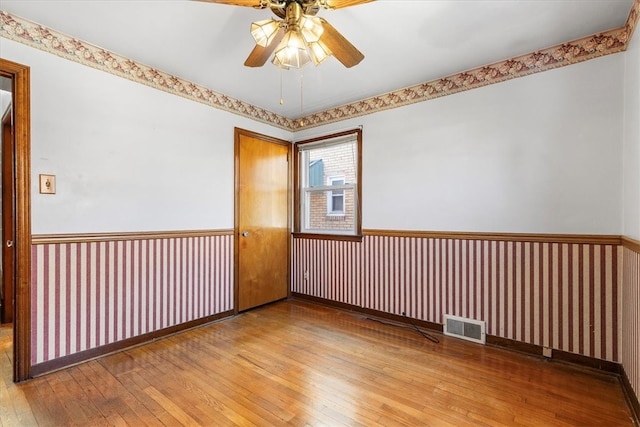 unfurnished room with hardwood / wood-style flooring and ceiling fan