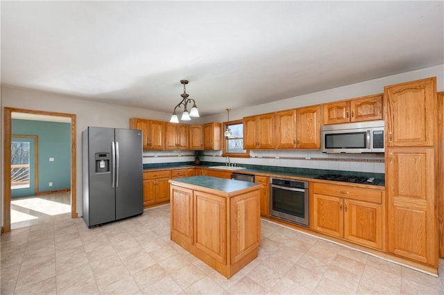 kitchen with appliances with stainless steel finishes, a center island, decorative light fixtures, decorative backsplash, and a chandelier