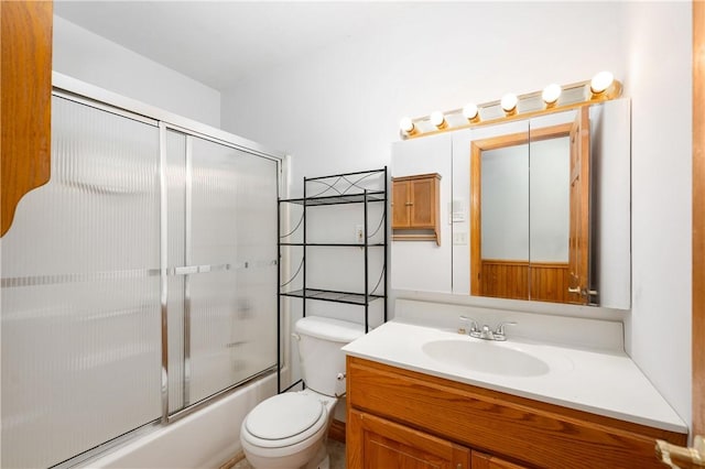 full bathroom featuring bath / shower combo with glass door, toilet, and vanity