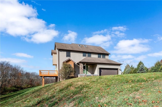 view of front of home with a front yard, a deck, and a garage