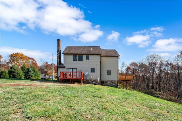 rear view of property featuring a deck and a yard