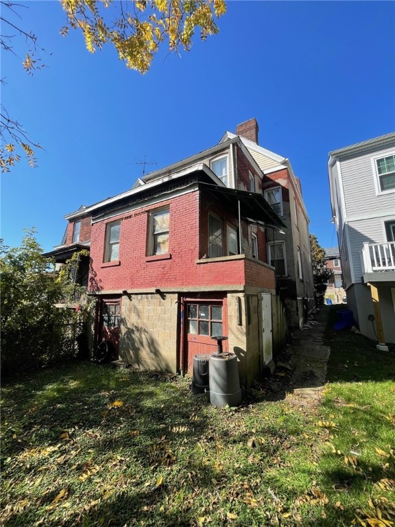 back of property featuring a lawn