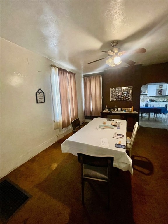 carpeted dining room with ceiling fan