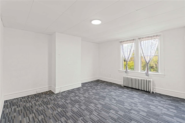 carpeted empty room with radiator heating unit