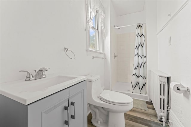 bathroom featuring hardwood / wood-style flooring, radiator, curtained shower, vanity, and toilet