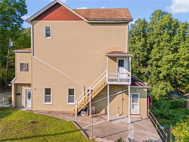 back of property featuring a patio area and a lawn