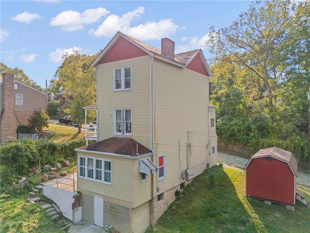 back of property featuring a shed and a yard